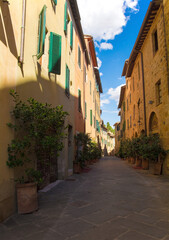 A residential road leads to the Collegiata dei Santi Quirico e Giulitta in the historic medieval village of San Quirico D'Orcia, Siena Province, Tuscany, Italy
