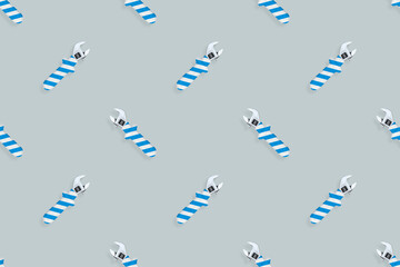 Adjustable wrench seamless pattern. Background made of a metal adjustable wrench with a rubber striped handle. 
