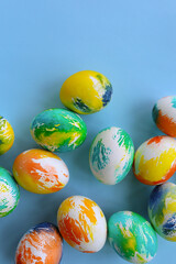 Top view of multicolored Easter eggs on a blue background. Happy Easter card. Dyed Easter eggs. Copy space for your text. Flat lay style. Top view. 
