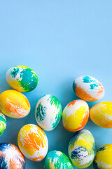 Top view of multicolored Easter eggs on a blue background. Happy Easter card. Dyed Easter eggs. Copy space for your text. Flat lay style. Top view. 