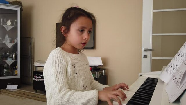 little pianist. the Pretty Girl is at home taking piano lessons. tiny fingers and musical notes