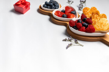 Valentine's day breakfast with red heart shaped candles and flowers on white background