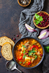 Homemade Meat Tomato soup with beef and bean stew, vegetables on a stone tabletop. Top view flat lay. Copy space.
