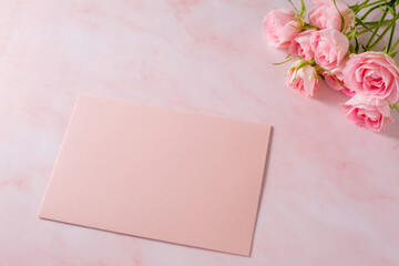 Pink rose and letter on marble background