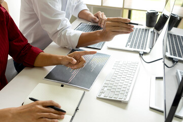 Two programmers are discussing on-screen work with computer