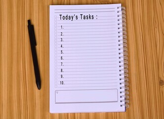 Text on notepad and pen with wooden background