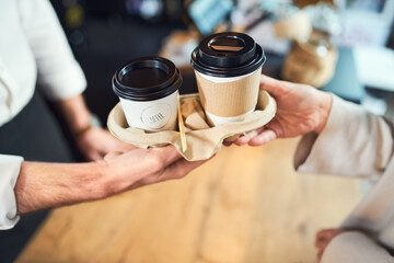 Fototapeta na wymiar Take away coffee. Closeup of barista serving takeaway cups of coffee