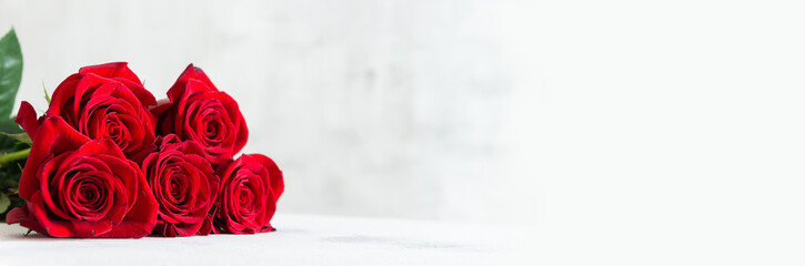 Red roses banner. Happy St. Valentine's Day, Mother's Day, Women's Day web line. Roses bouquet on white background with copy space or product place. Festive banner design