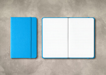 Blue closed and open lined notebooks on concrete background