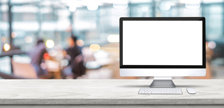 Blank screen desktop computer on wooden table top with blur people working at creative office bokeh background,Mock up for display or montage of design