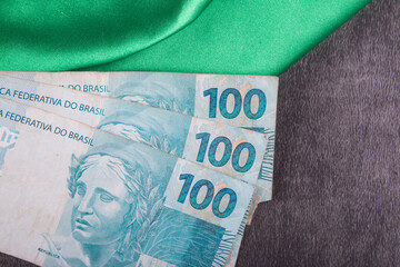 One hundred reais notes on Brazilian flag