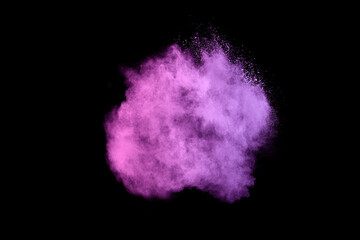 Freeze motion of purple color powder exploding on black background.