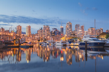Fototapeta na wymiar Evening cityscape view of Granville Island and Vancouver downtown waterfront skyline from Island Park Walk.