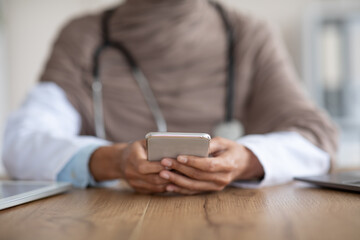 Cropped of female doctor with smartphone in clinic
