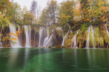 Waterfalls flow into an emerald pool on an autumn day at Plitvice Lakes National Park in Croatia