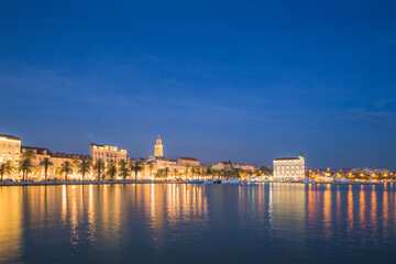 An evening view of the city lights of the Split waterfront and promenade on the Adriatic coast of Croatia.
