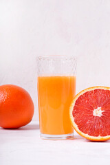 Blood orange juice freshly squeezed in the drinking glass with pulp and the fruits around on the...