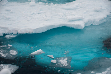 Close view of melting arctic sea ice with turquoise blue ice form under water.j