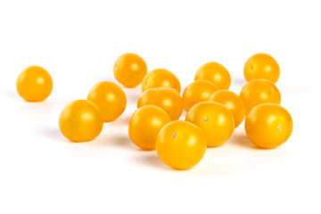 multiple yellow cherry tomatoes on a white background with shadow