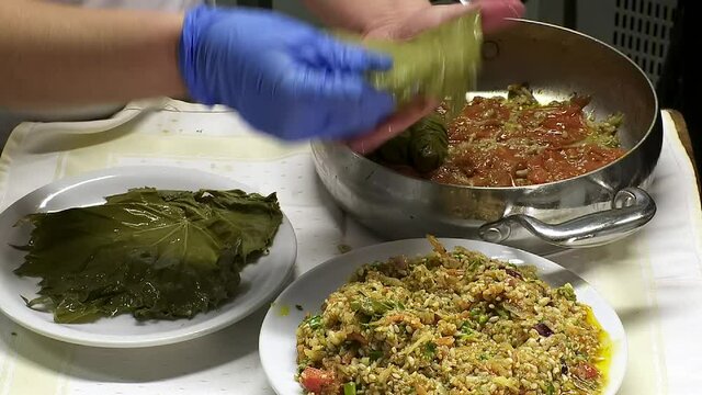 Rhodes Greece: preparing to Cooke dolmadakia or sarmadakia a traditional Greek plate made by staffed vine leaves with mainly rise 