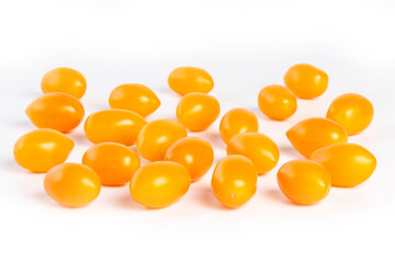multiple yellow cherry tomatoes on a white background with shadow