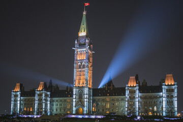 Canada's Parliament Hill building in Ottawa lights up at night for an impressive display and significant tourist attraction.