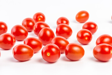 a few tomatoes on a white background with a shadow.
