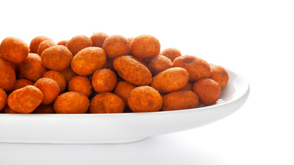 Crunchy Peanut in a white ceramic oval bowl, made with besan coated peanuts. Pile of Indian spicy snacks (Namkeen), under backlight, side view, against the white background.