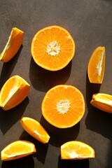 Colorful, fresh orange slices on a dark background. View from the top.