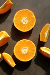 Fototapeta na wymiar Colorful, fresh orange slices on a dark background. View from the top.