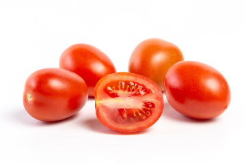 a group of tomatoes on a white background, with shadows. One tomato cut, studio photo, isolate, tomatoes washed