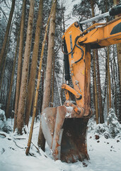 Large orange excavator bucket covered with snow in winter forest. Vertical orientation
