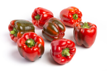 a group of Bulgarian sweet peppers on a white background, with shadows. studio photo, isolate, peppers washed. Peppers are red, with green spots