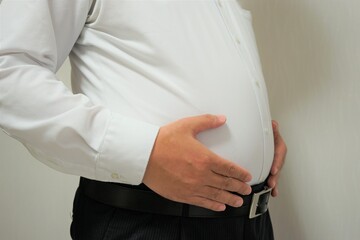 Overweight businessman body with hands touching belly fat - お腹の出ているビジネスマン