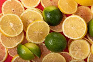 Fototapeta na wymiar fresh limes and lemons sliced on red chopping board