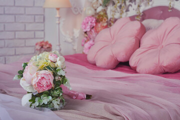 bouquet of pink flowers on the bed in the bedroom