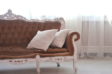 brown velvet sofa near the window