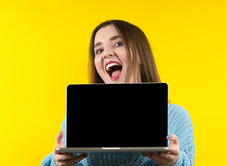 Happy woman with laptop computer isolated on yellow background