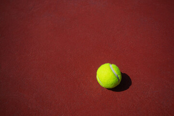 The tennis ball is placed on a red floor.	
