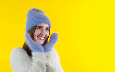 Emotional girl in winter hat, gloves and  expressing happiness