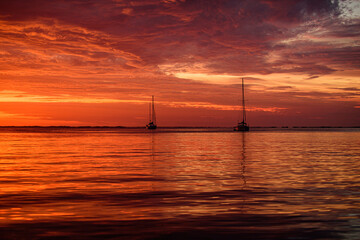 Yachting and traveling. Boat on ocean sea at sunset. Sailboats with sails.