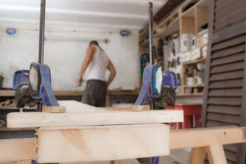 Fototapeta premium Male carpenter working with wood material in a garage.