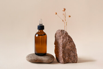 Cosmetic in a glass bottle on stone podium, dried flower on beige background. Front view.