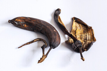 Dried up rotten decomposed banana and peel on white table - concept and idea background