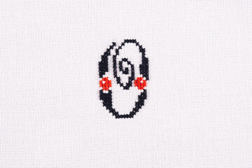 Letter O of Embroidered Cross - Stitch Latin Alphabet on White Linen Fabric Handmade Close-up