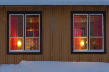 lights in houses in the evening in winter with snow