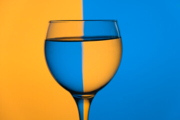 Copo de vidro com cor azul e amarelo de fundo