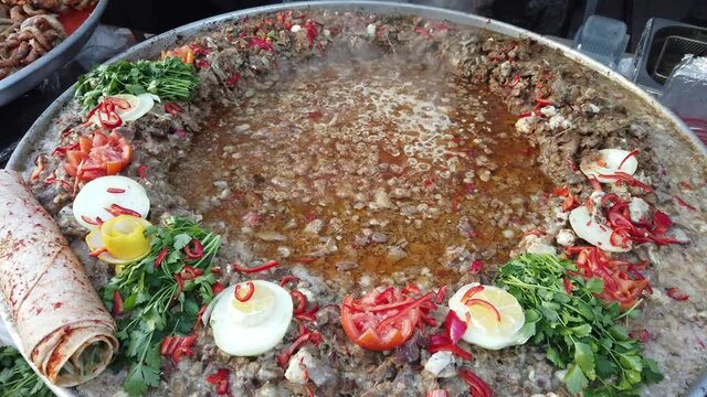 roasting hair made from lamb meat on a large tray. with tomato, pepper and onion sauce. Turkish food eaten by placing between bazlama and phyllo dough(yufka). &ldquo;belen tava&rdquo;