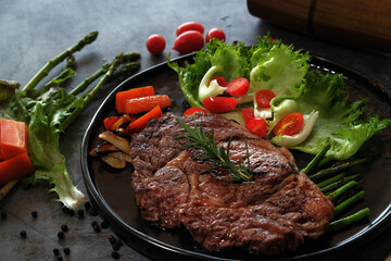 Beef Steaks in a Hot Plate on a Dark Floor