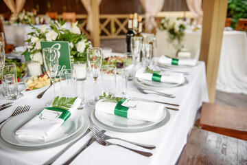 Table setting with sparkling wineglasses, plate with white napkin and cutlery on table, copy space. Place set at wedding reception. Table served for wedding banquet in restaurant